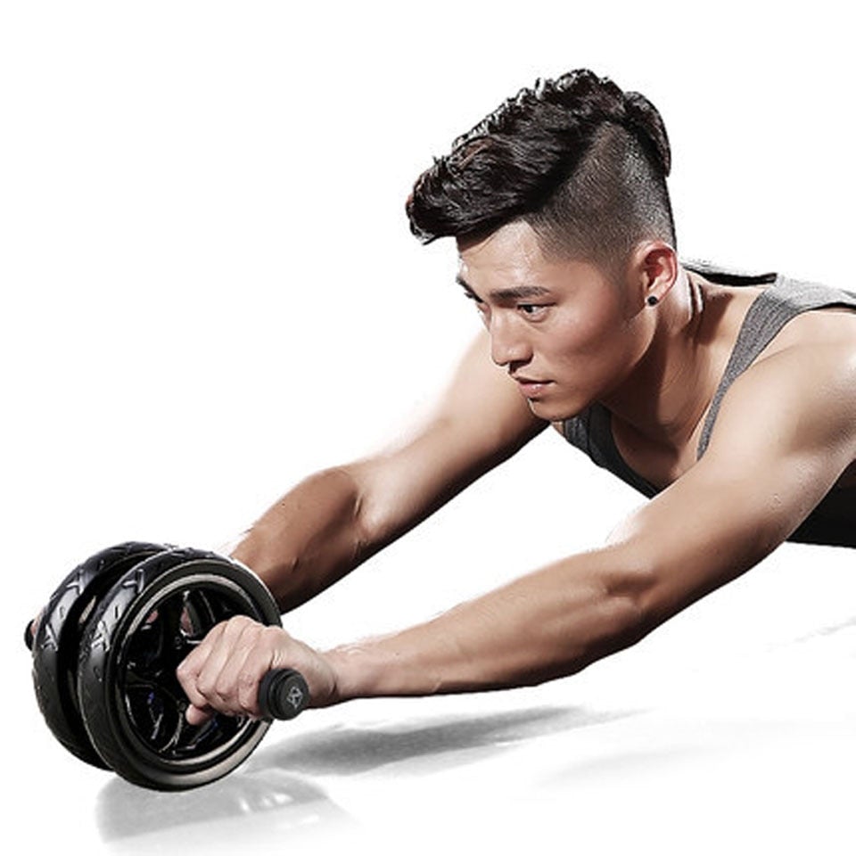 Ab roller trainer with black wheels and foam grips during plank exercise