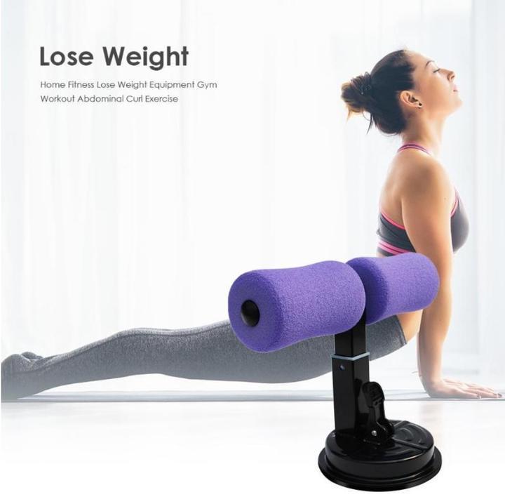 Purple foam sit-up suction bar with dual rollers on a workout mat