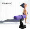 Purple foam sit-up suction bar with dual rollers on a workout mat