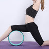 Teal-rim yoga wheel ring supporting a standing lunge pose
