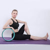 Teal-rim yoga wheel ring beside a seated stretching pose
